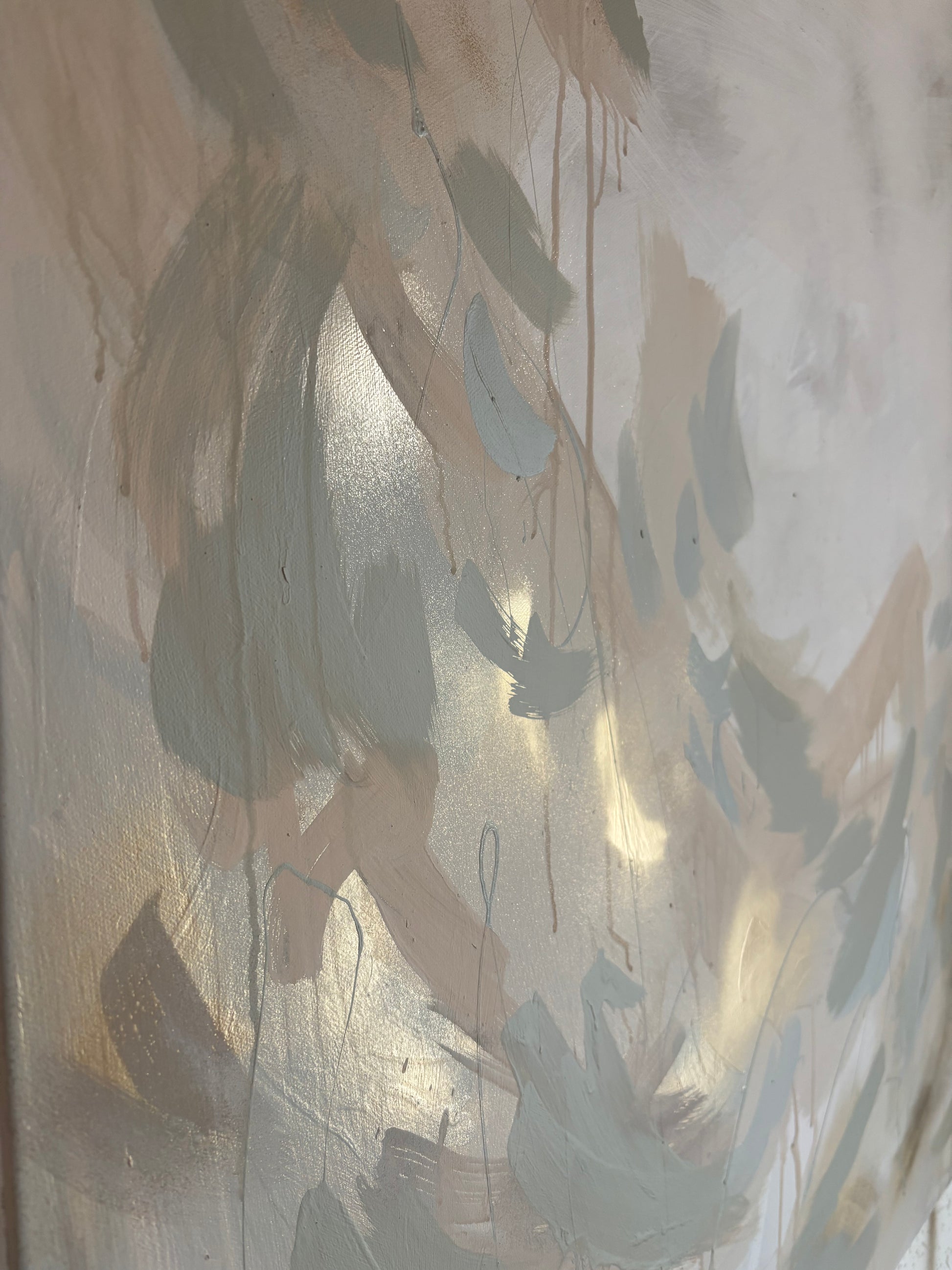 Close up of contemporary soft and elegant lustful abstract painting by uk artist Briony May Richardson at StudioBMR. Large brush strokes appear like feathers as they dance across the canvas in dusty pink and sage green tones. Background is washed in grey tones featuring specs of gold. Capturing paint drips and reflective metallic angles