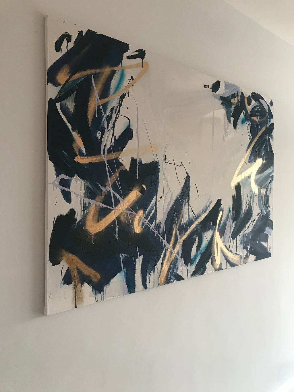 Ink blue and navy tone contemporary abstract layer painting with chaotic gestural splatters and spray paint markings. Lilac and gold elements on a grey washed canvas. Painted by Artist Briony May Richardson at StudioBMR.